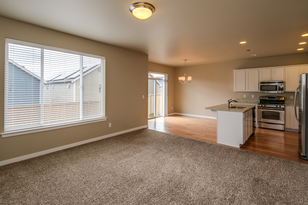 Property Photo: Looking toward the kitchen and dining area with hardwood flooring. there are like-new stainless appliances including the gas range, and microwave, dishwasher and refrigerator. 4713 Hadley St  WA 98226 